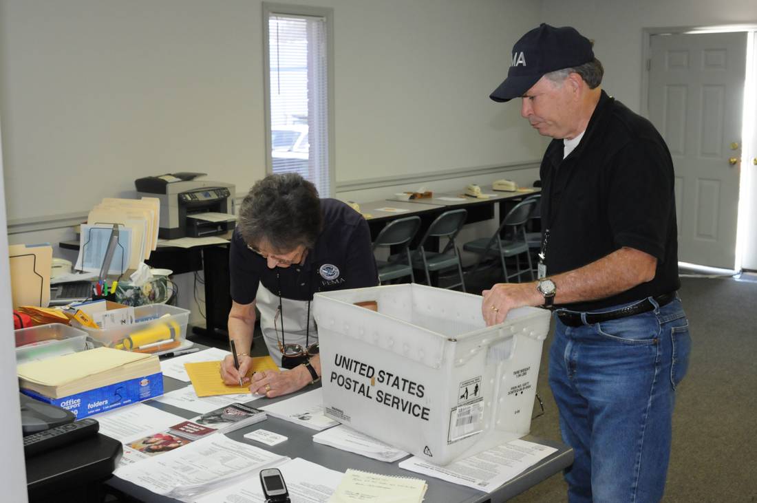 Postal and delivery services worker, at work