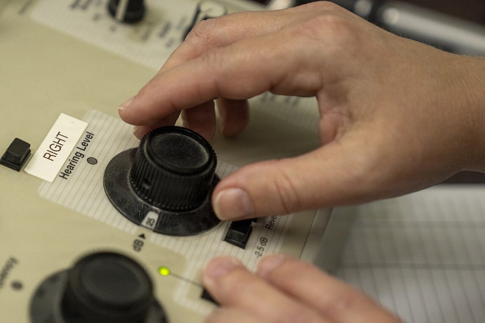 Hearing care professional adjusting the hearing level on an audiometer during a hearing test